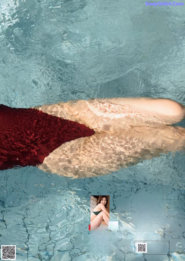 A woman in a red bikini laying in the water.