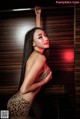 A woman in a leopard print lingerie posing for a picture.