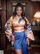 A woman in a blue and orange kimono posing for a picture.