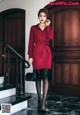 A woman in a red dress is standing on the stairs.