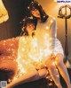 A couple of women sitting on top of a couch covered in lights.