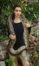 A woman in a black bodysuit holding a large snake.