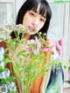 A woman holding a bunch of flowers in front of her face.