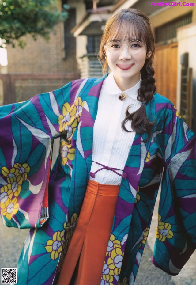 A woman wearing a colorful kimono standing in front of a building.