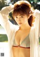 A woman in a white shirt is posing for a picture.
