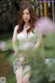 A woman in a white lingerie sitting on a bench.