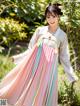 A woman in a pink and blue hanbok is posing for a picture.